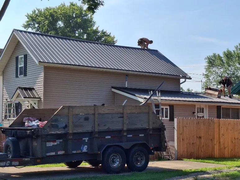 Hershberger Brothers Roofing crew installing a metal roof on a two-story home
