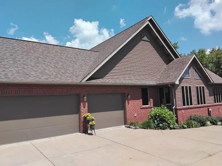 Finished shingle roof by Hershberger Brothers Roofing, with the yard and driveway cleaned up
