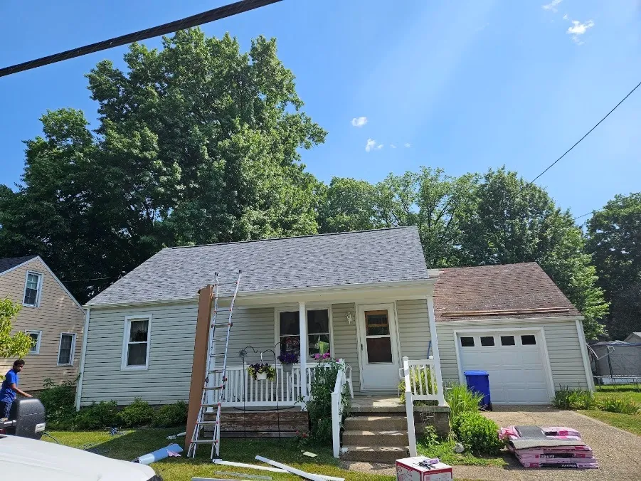 Hershberger Brothers Roofing crew working on the roof edge and gutters of a home with a front porch